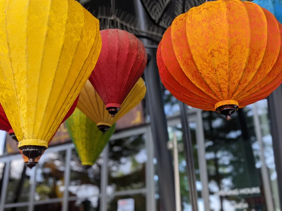 Yellow, red and orange paper lanterns glowing against the sky