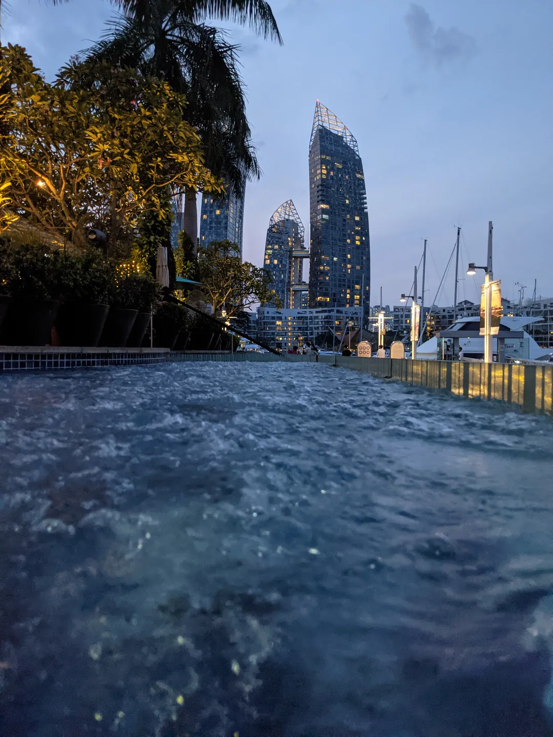 Rippling pool water meeting a city skyline at dusk