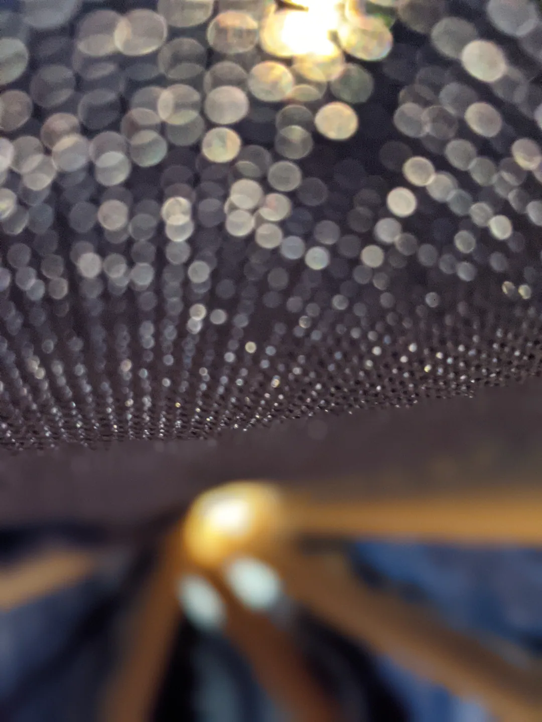 Glowing circles of light through tent mesh beside a wooden pole