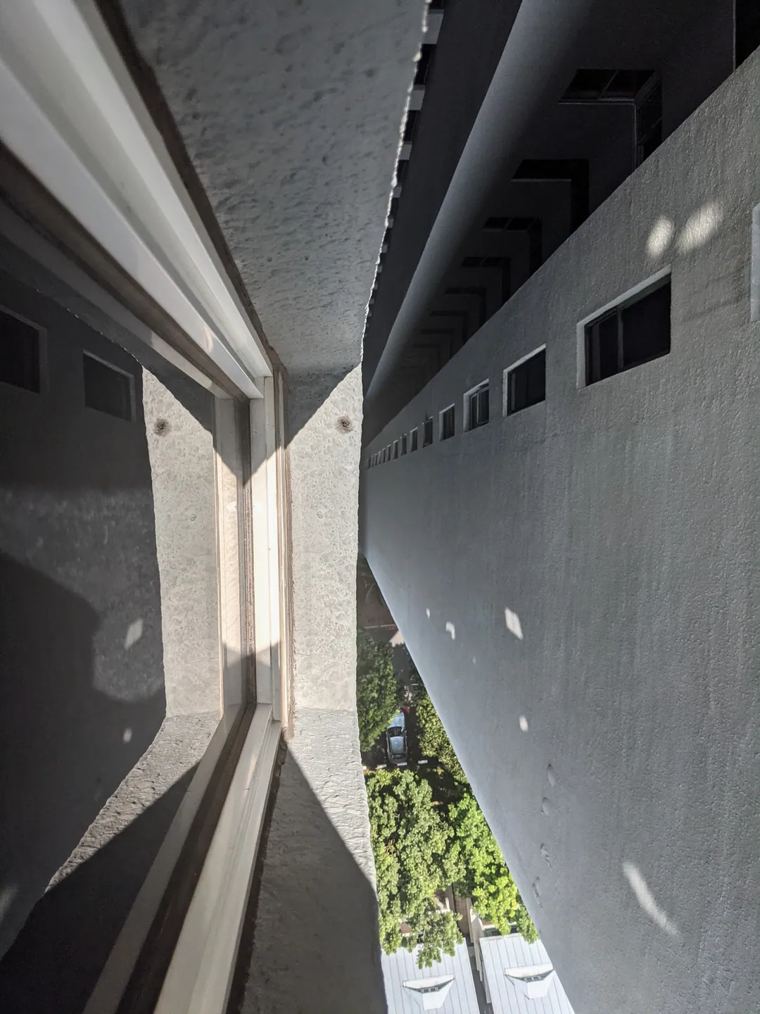 Two tall building walls rising to a narrow strip of sky